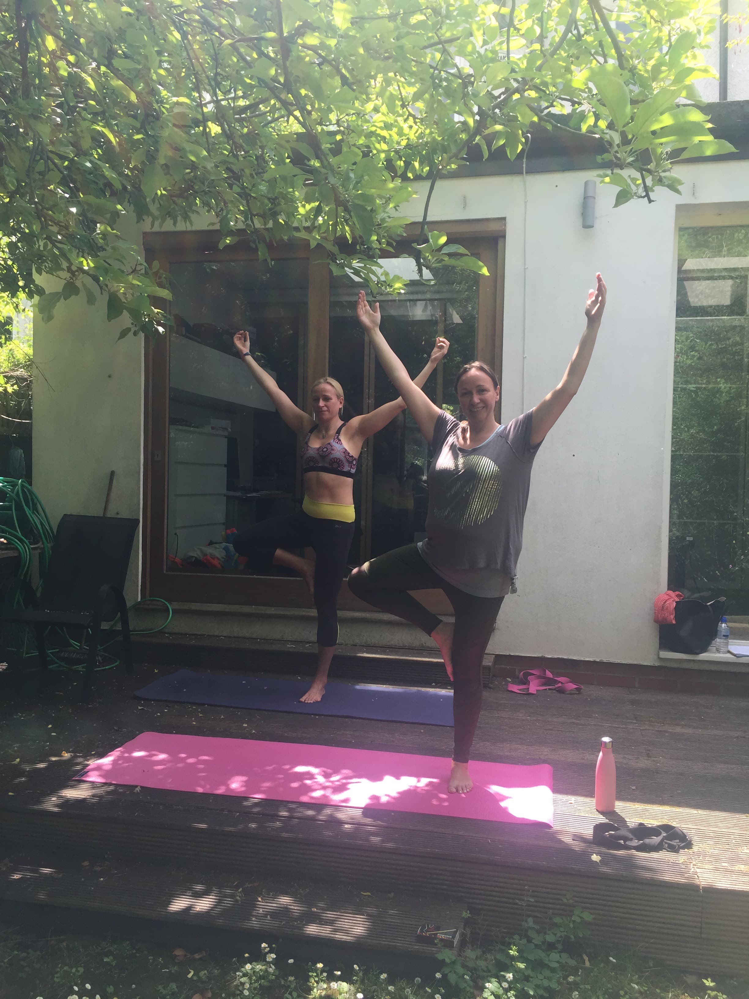 Two members practising tree pose outdoors